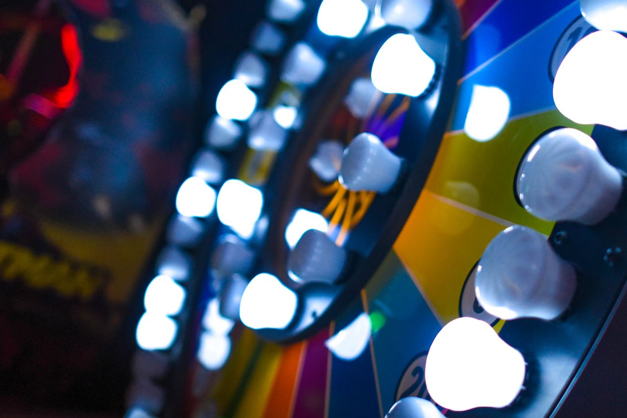 Close-up of a colorful arcade game wheel with bright lights and vivid colors in focus.